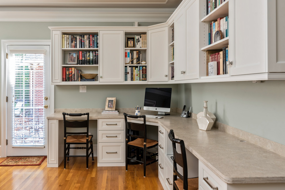 Aménagement d'un petit bureau classique avec un mur vert, parquet clair, un bureau intégré et un sol marron.