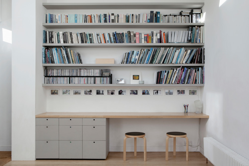 Inspiration för moderna arbetsrum, med vita väggar, ljust trägolv, ett inbyggt skrivbord och beiget golv