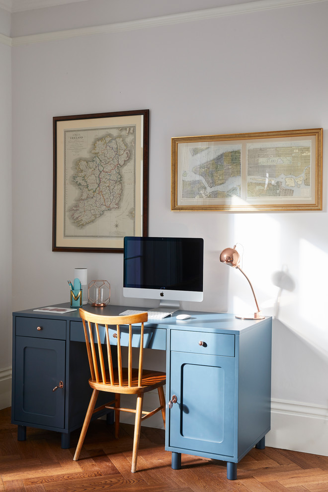 Aménagement d'un petit bureau victorien avec un sol en bois brun, un bureau indépendant, un sol marron et un mur blanc.