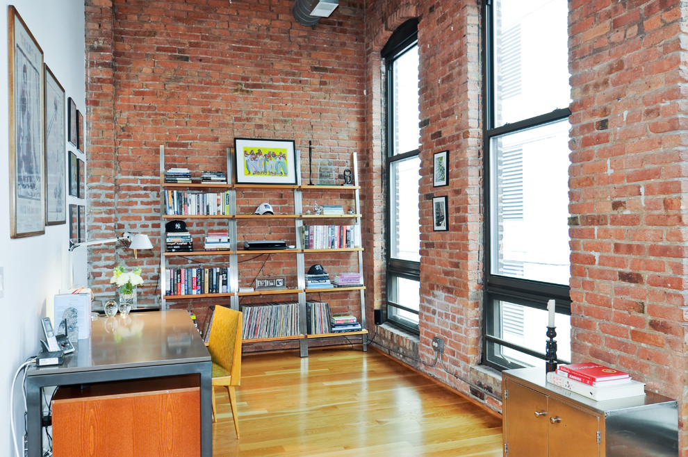 Foto de despacho urbano sin chimenea con paredes rojas, suelo de madera en tonos medios y escritorio independiente