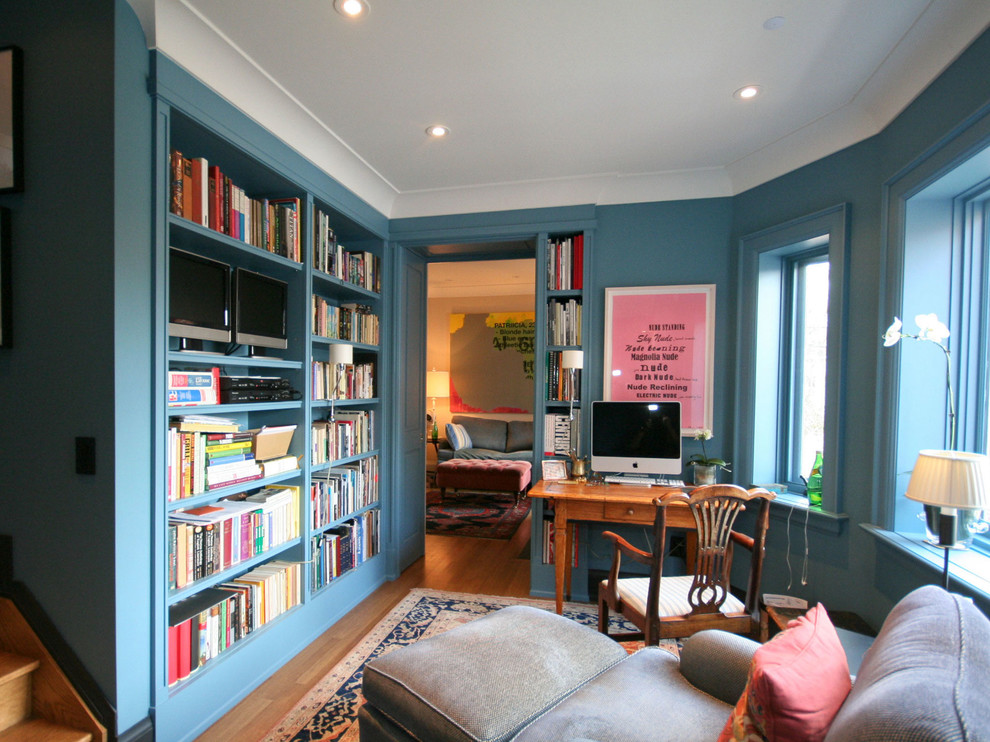 Ejemplo de despacho tradicional de tamaño medio con paredes azules, suelo de madera en tonos medios y escritorio independiente