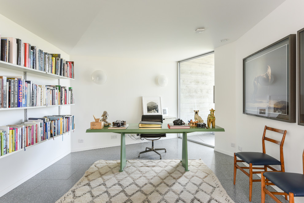 Klassisk inredning av ett arbetsrum, med vita väggar, ett fristående skrivbord och grått golv