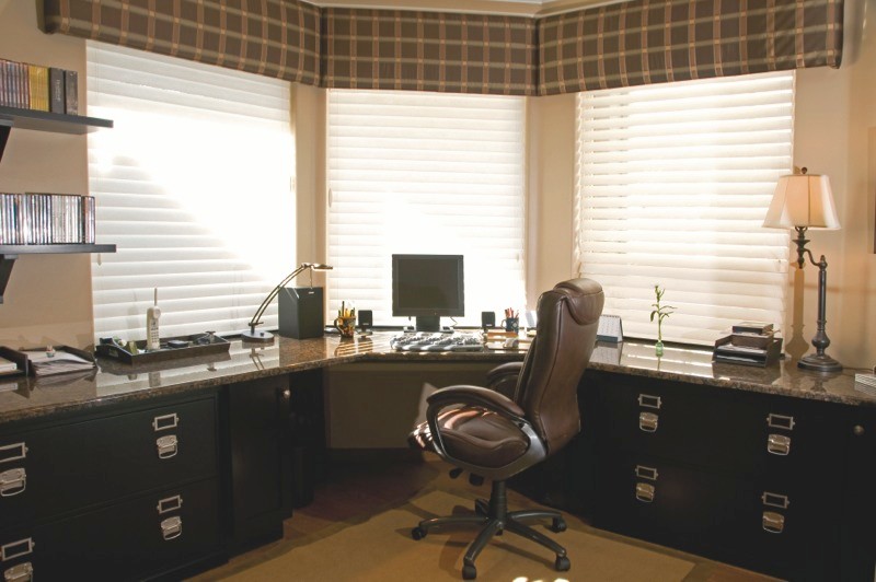 Cette photo montre un très grand bureau chic de type studio avec un mur beige, un sol en bois brun, aucune cheminée et un bureau intégré.