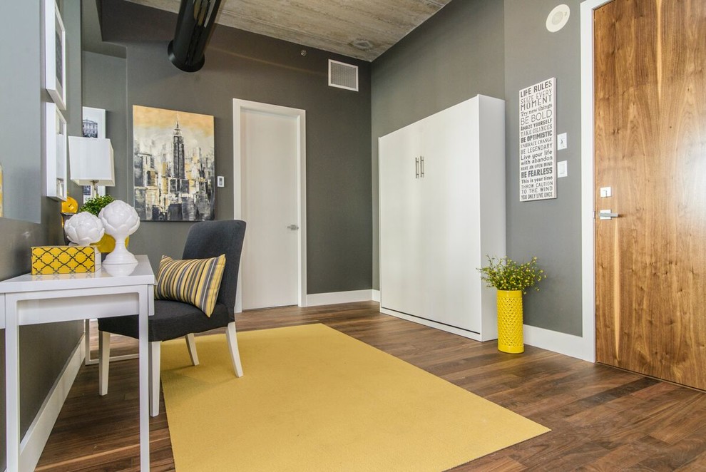 Imagen de despacho minimalista de tamaño medio sin chimenea con paredes grises, suelo de madera oscura y escritorio independiente