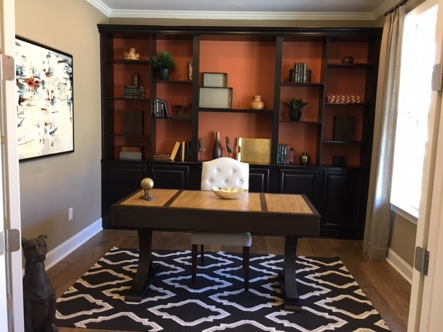 Imagen de despacho minimalista de tamaño medio con paredes grises, suelo de madera en tonos medios, escritorio independiente y suelo marrón