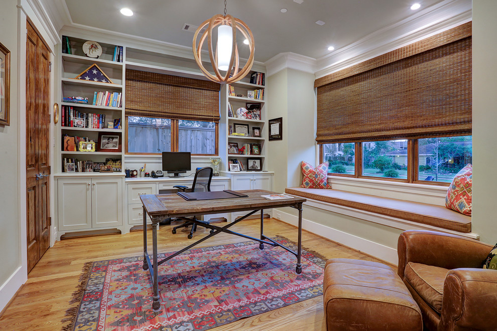 Modelo de despacho tradicional con paredes beige, suelo de madera en tonos medios, escritorio independiente y suelo beige