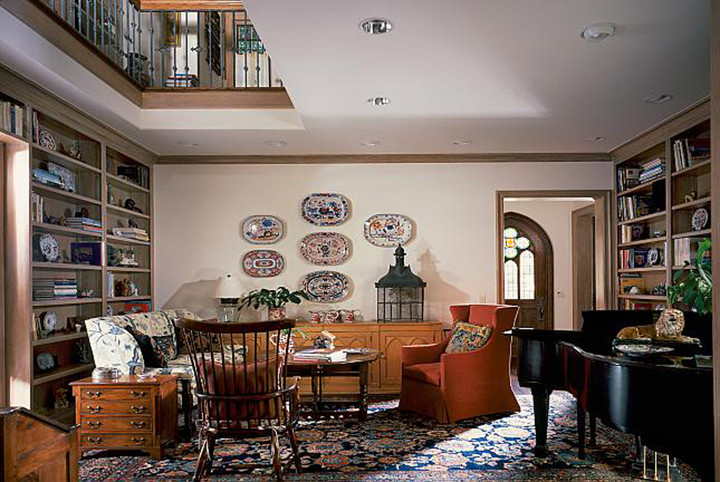 Exempel på ett klassiskt hemmabibliotek, med beige väggar och ett fristående skrivbord