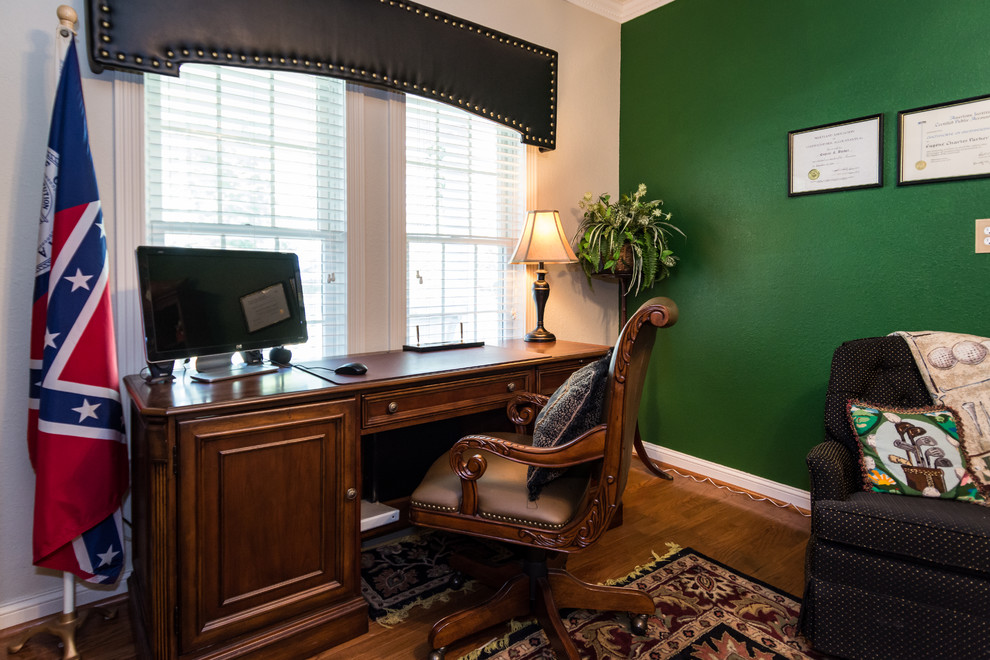 This is an example of a large classic home office in Other with green walls, medium hardwood flooring and a freestanding desk.