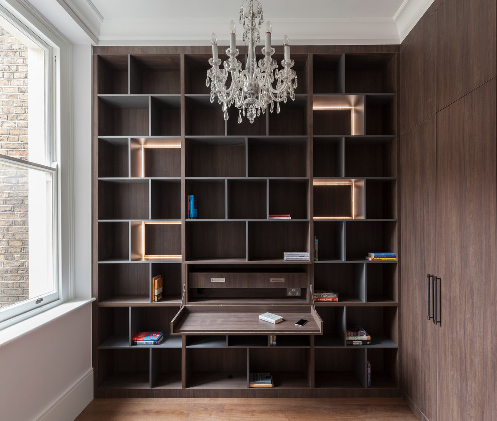 Ejemplo de estudio tradicional renovado pequeño con paredes blancas, suelo de madera clara y escritorio empotrado