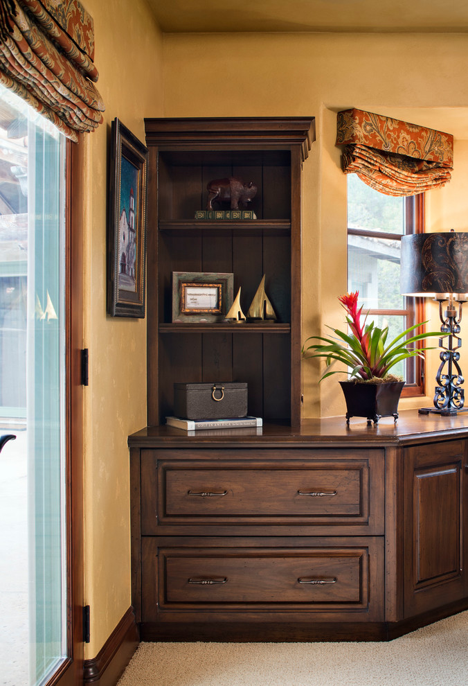Foto de despacho mediterráneo de tamaño medio sin chimenea con moqueta, escritorio independiente y paredes amarillas
