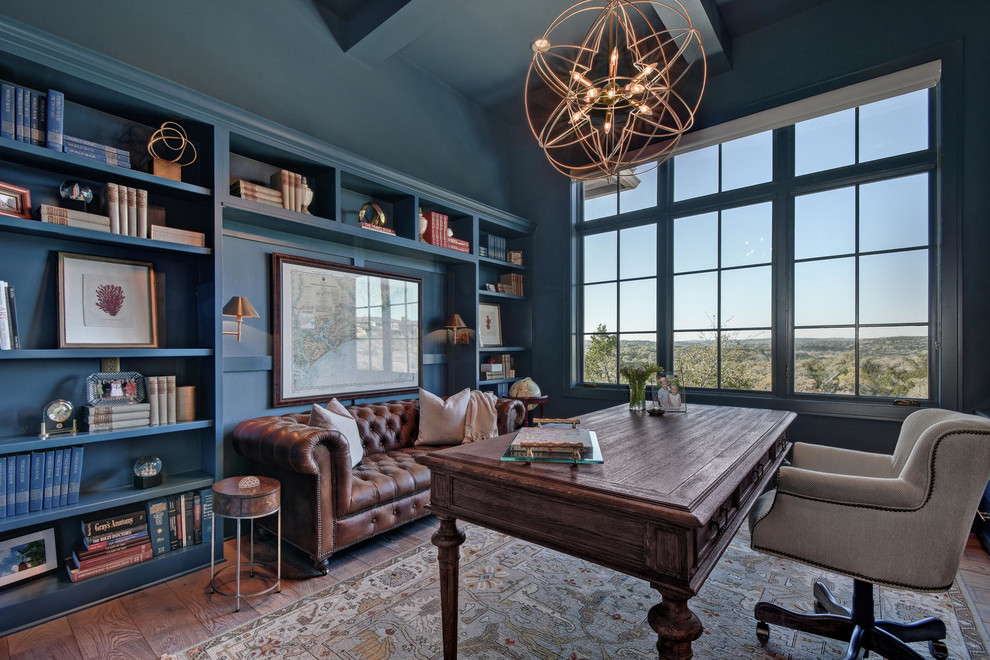 На фото: большой кабинет в классическом стиле с синими стенами, темным паркетным полом, отдельно стоящим рабочим столом и коричневым полом