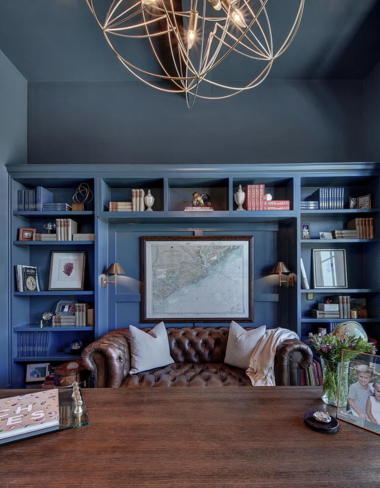 Réalisation d'un grand bureau tradition avec un mur bleu, parquet foncé et un bureau indépendant.