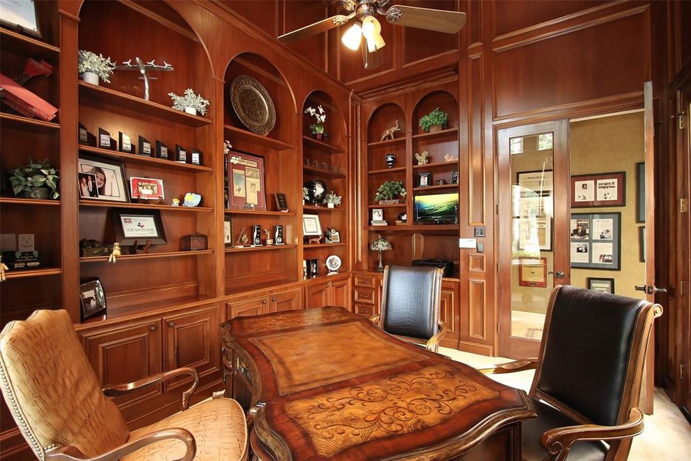 Example of a huge tuscan freestanding desk travertine floor and beige floor study room design in Houston with brown walls