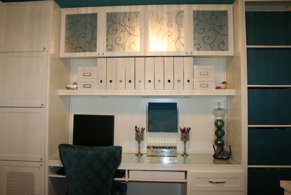 Ejemplo de despacho actual pequeño sin chimenea con paredes blancas, suelo de corcho, escritorio empotrado y suelo marrón