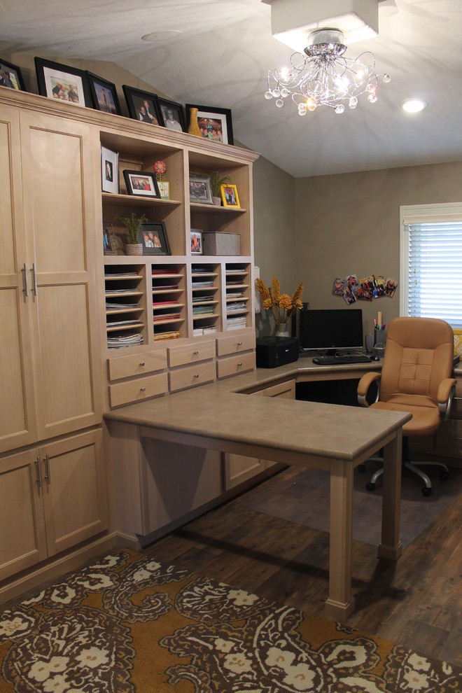 Example of a large classic built-in desk dark wood floor craft room design in Other with beige walls