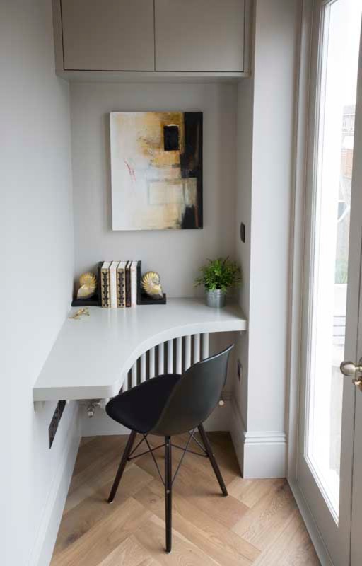 Foto de despacho actual pequeño con paredes grises, suelo de madera clara y escritorio empotrado