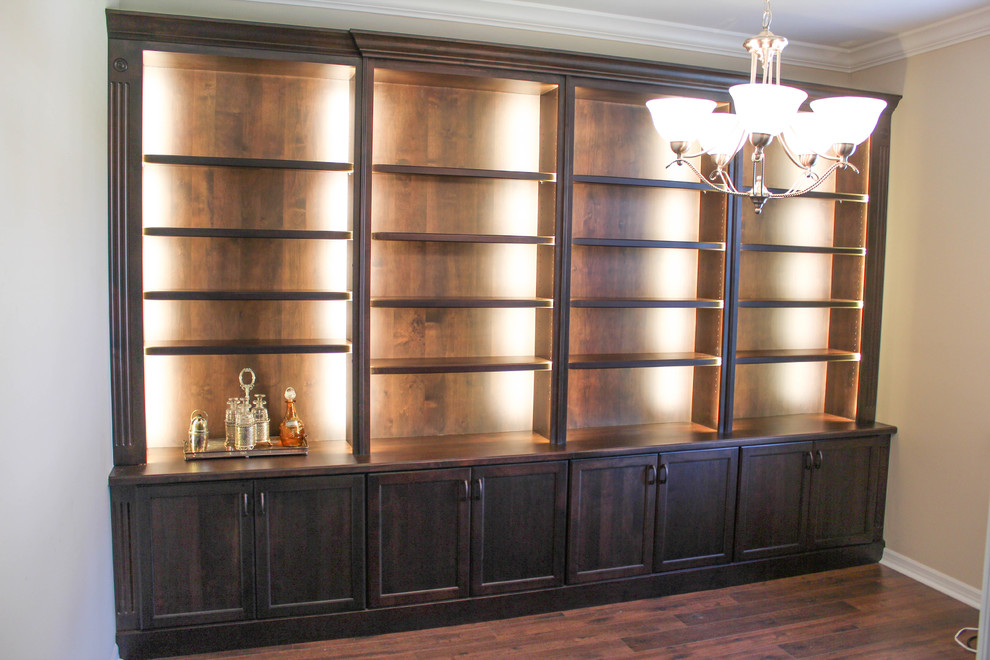 Ejemplo de despacho tradicional de tamaño medio sin chimenea con paredes beige y suelo de madera oscura