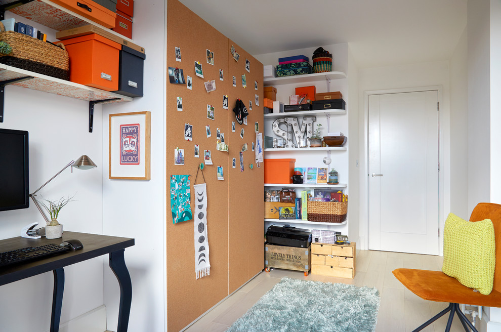 Kleines Modernes Arbeitszimmer ohne Kamin mit Arbeitsplatz, schwarzer Wandfarbe, hellem Holzboden, freistehendem Schreibtisch und grauem Boden in London