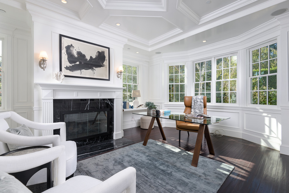 Inspiration for a large traditional study in Los Angeles with white walls, dark hardwood flooring, a standard fireplace, a tiled fireplace surround, a freestanding desk and brown floors.