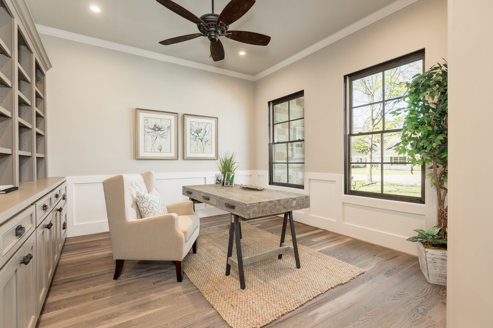 Landhaus Arbeitszimmer mit grauer Wandfarbe, hellem Holzboden und freistehendem Schreibtisch in Houston