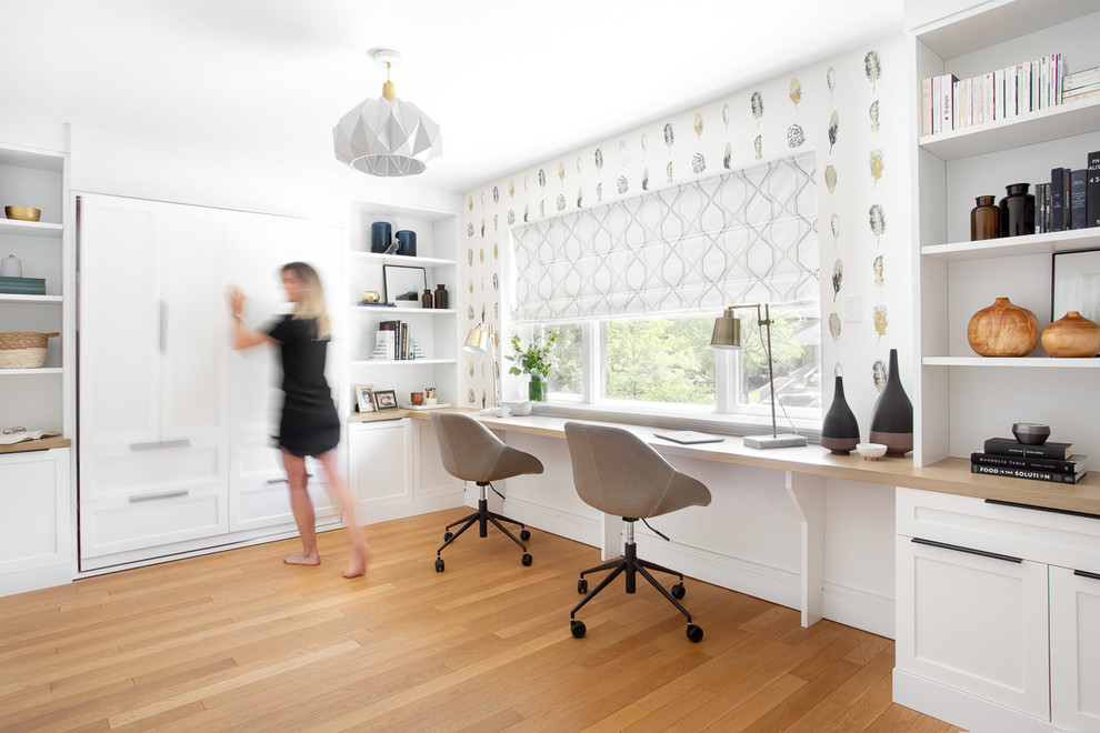 Cette photo montre un bureau tendance de taille moyenne avec un mur blanc, parquet clair, aucune cheminée, un bureau intégré et un sol marron.