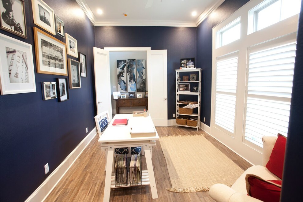 Mittelgroßes Stilmix Arbeitszimmer mit Arbeitsplatz, blauer Wandfarbe, braunem Holzboden und freistehendem Schreibtisch in Austin