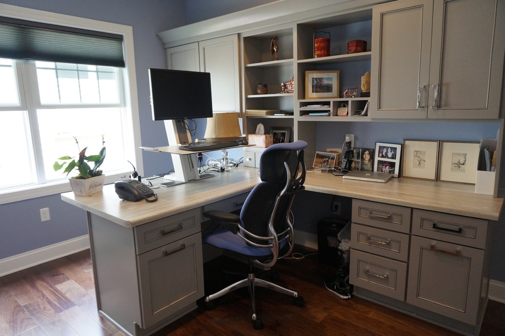 Réalisation d'un bureau tradition de taille moyenne avec un mur bleu, parquet foncé, aucune cheminée, un bureau intégré et un sol marron.