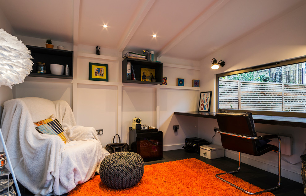 ロンドンにある小さなコンテンポラリースタイルのおしゃれなアトリエ・スタジオ (白い壁、造り付け机、黒い床) の写真