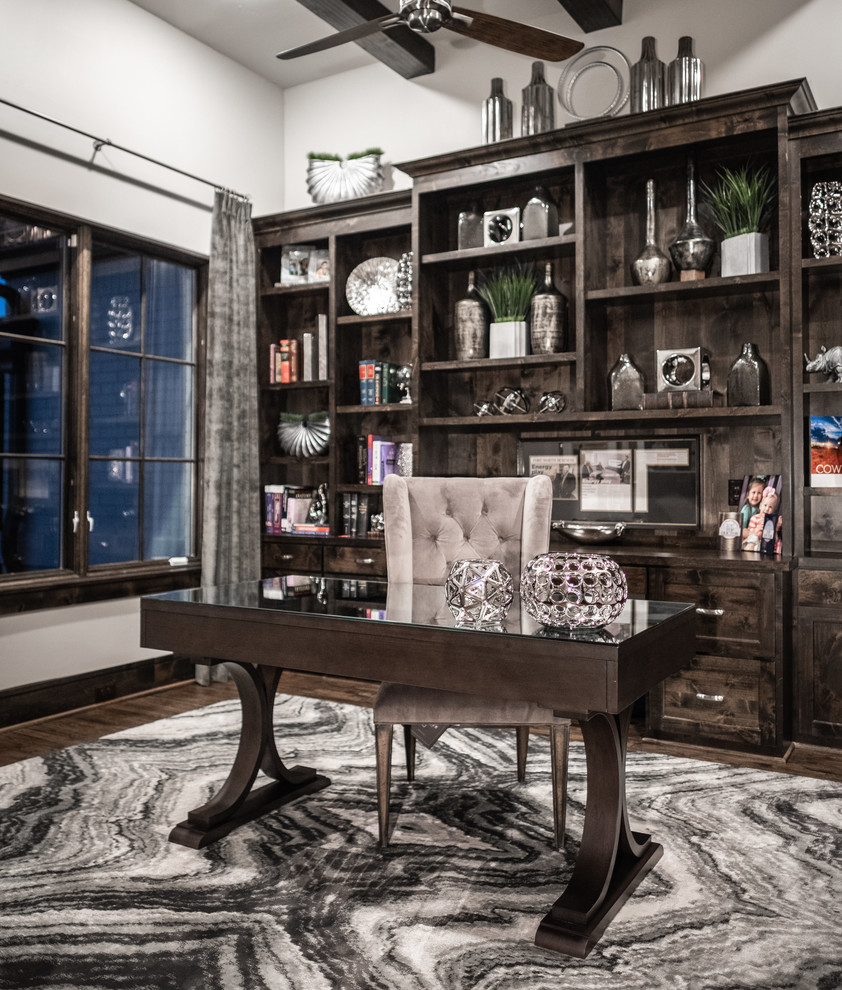 Modelo de despacho tradicional renovado con paredes grises, suelo de madera oscura, escritorio independiente y suelo marrón