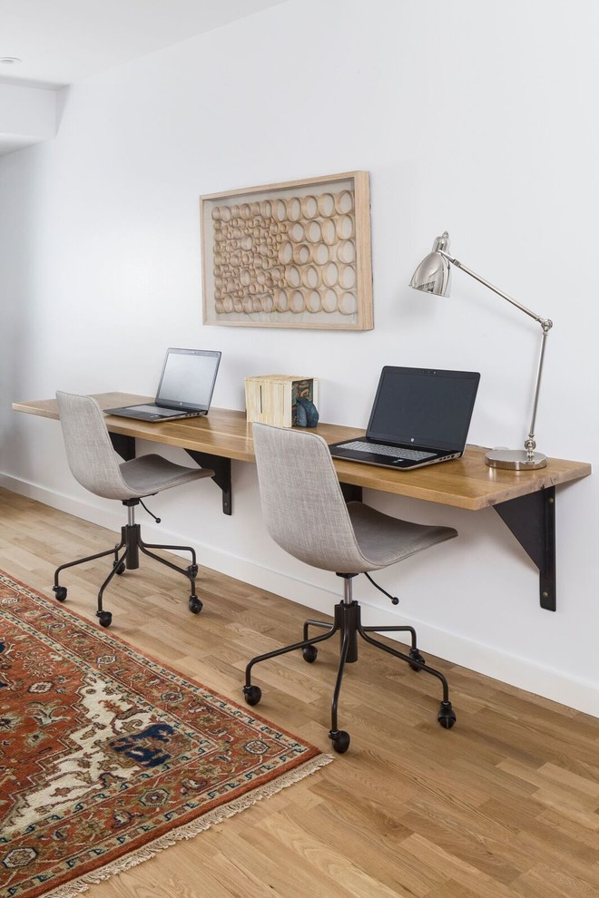Esempio di un grande ufficio minimalista con pareti bianche, parquet chiaro e scrivania incassata