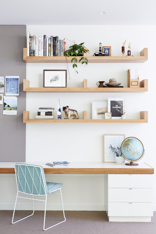 Стильный дизайн: кабинет в скандинавском стиле с белыми стенами, ковровым покрытием и встроенным рабочим столом - последний тренд