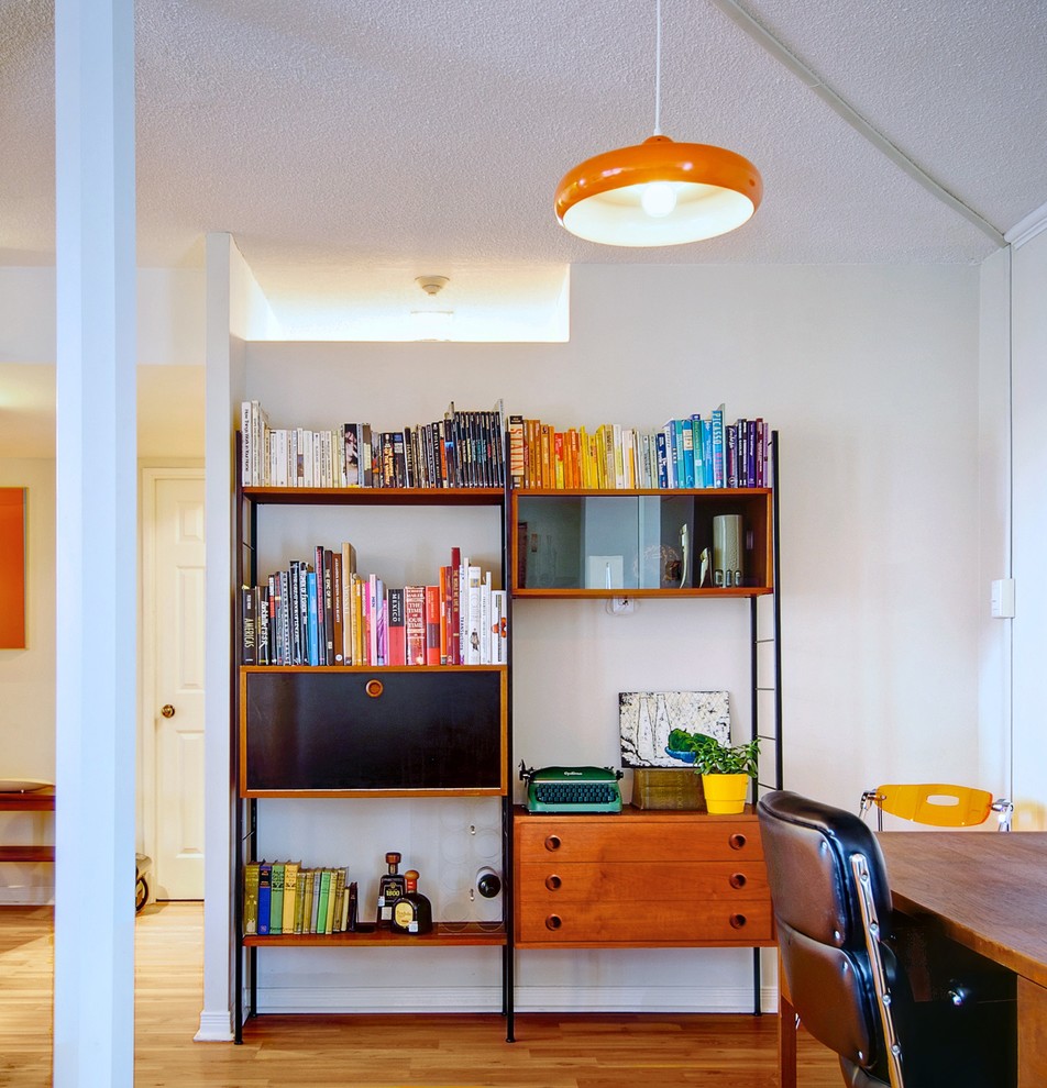 Diseño de despacho retro con paredes blancas y suelo de madera en tonos medios