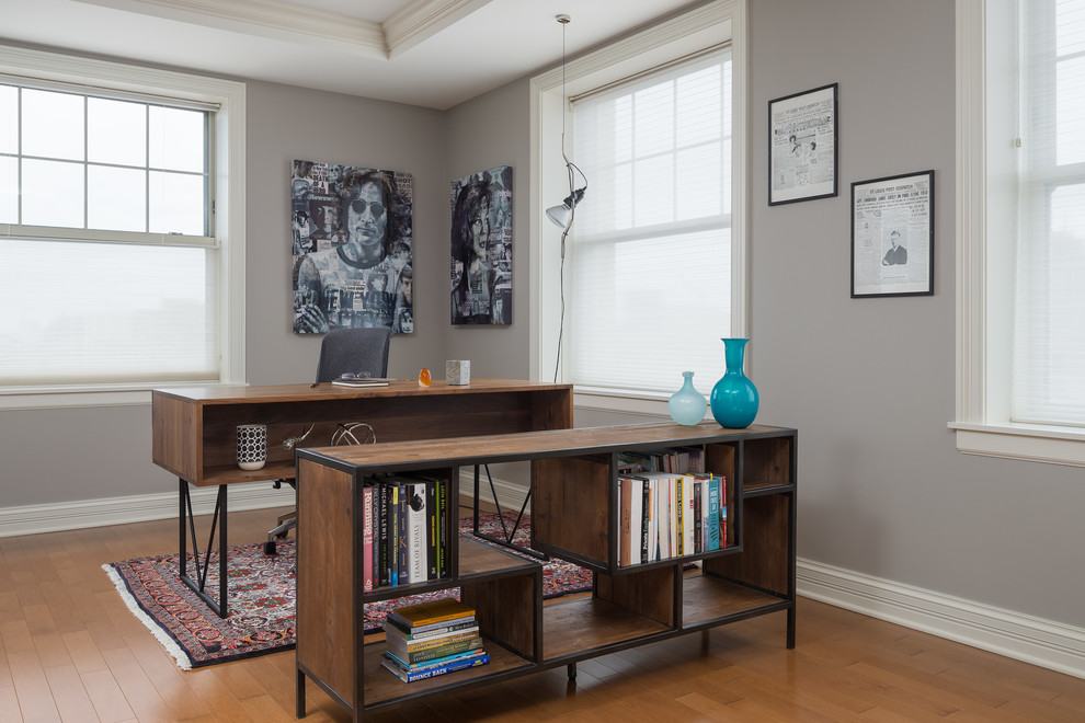 Foto de despacho actual de tamaño medio con paredes grises, suelo de madera en tonos medios y escritorio independiente