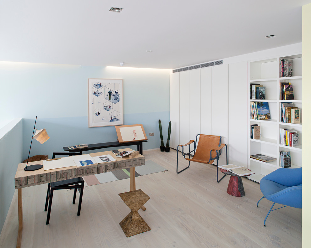 Design ideas for a medium sized scandi study in London with blue walls, light hardwood flooring, no fireplace and a freestanding desk.