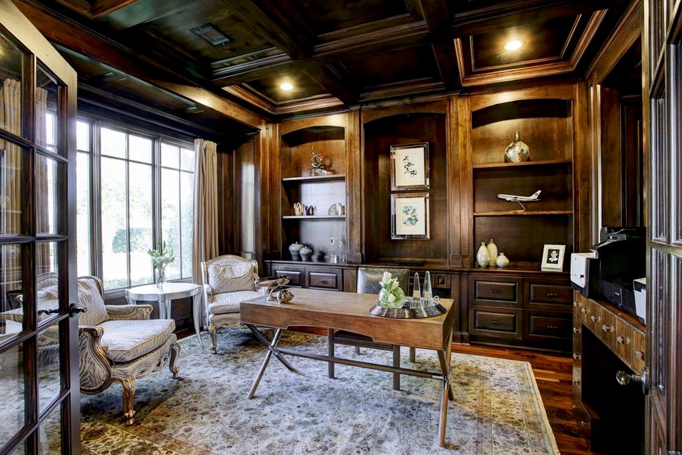 Klassisches Arbeitszimmer ohne Kamin mit dunklem Holzboden und freistehendem Schreibtisch in Houston