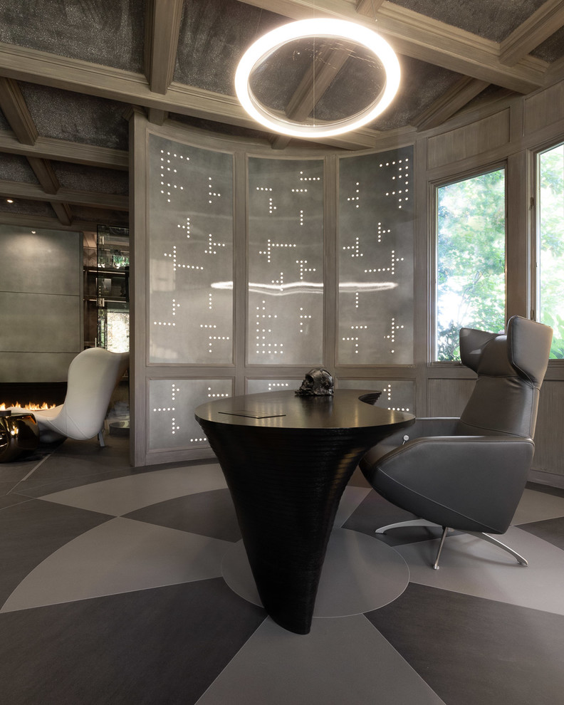 Immagine di uno studio minimal con pareti grigie, scrivania autoportante e pavimento grigio