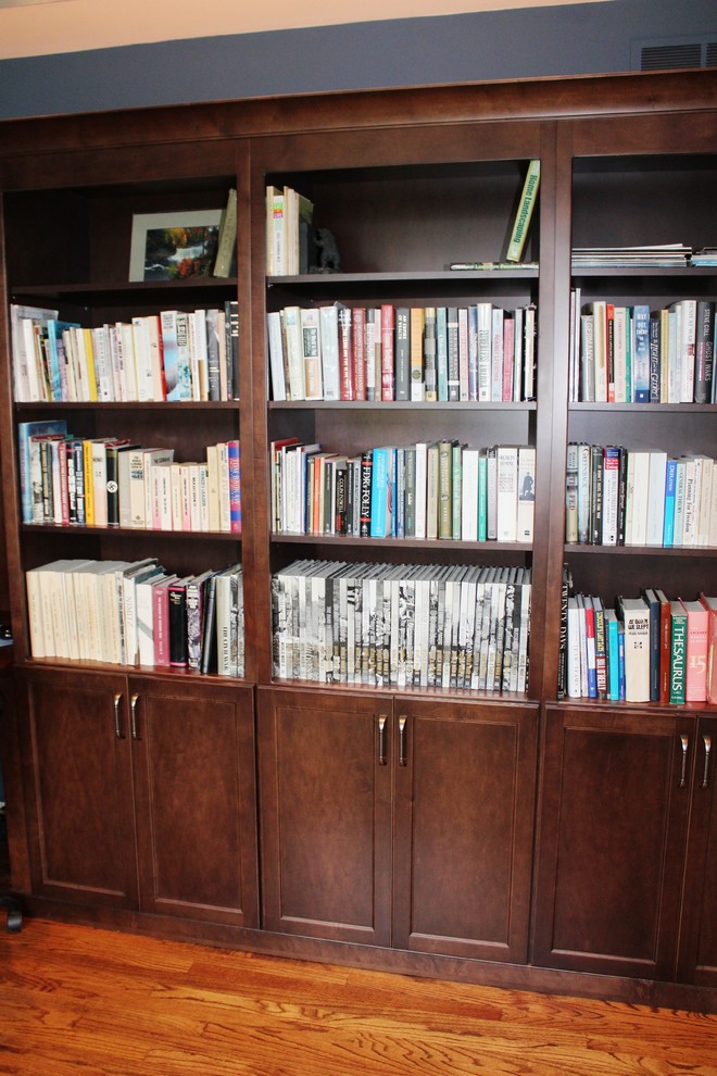 Foto de despacho clásico renovado de tamaño medio con biblioteca, paredes azules y escritorio empotrado