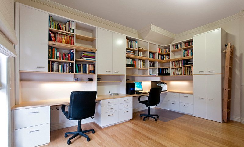 Großes Modernes Arbeitszimmer ohne Kamin mit Arbeitsplatz, weißer Wandfarbe, hellem Holzboden und Einbau-Schreibtisch in Melbourne