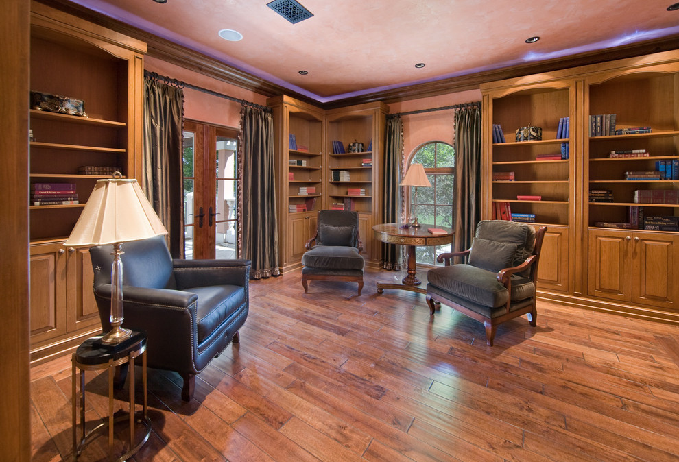 Example of a large tuscan light wood floor study room design in Orlando with pink walls and no fireplace