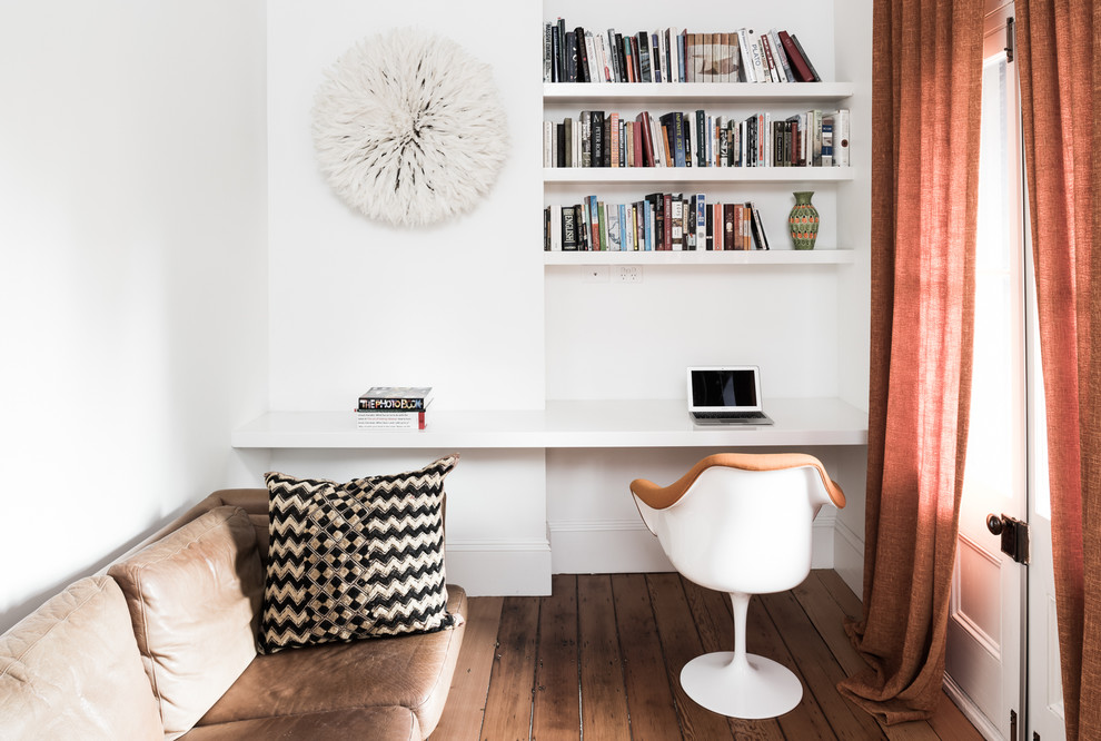 Imagen de despacho de tamaño medio con paredes blancas, suelo de madera oscura y escritorio empotrado