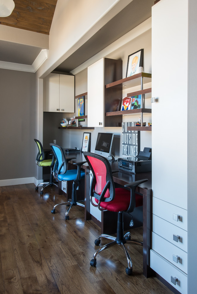 Exemple d'un bureau chic de taille moyenne avec un mur gris, un sol en bois brun et un bureau intégré.