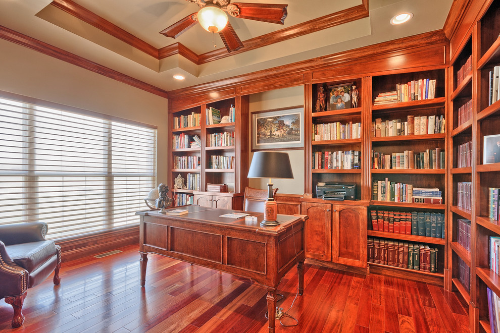 Imagen de despacho tradicional de tamaño medio con paredes beige, suelo de madera oscura y escritorio independiente
