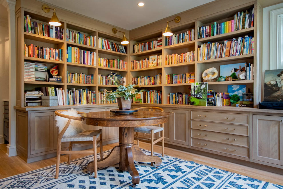 Kleines Landhaus Lesezimmer mit weißer Wandfarbe, hellem Holzboden, freistehendem Schreibtisch und braunem Boden in Sonstige