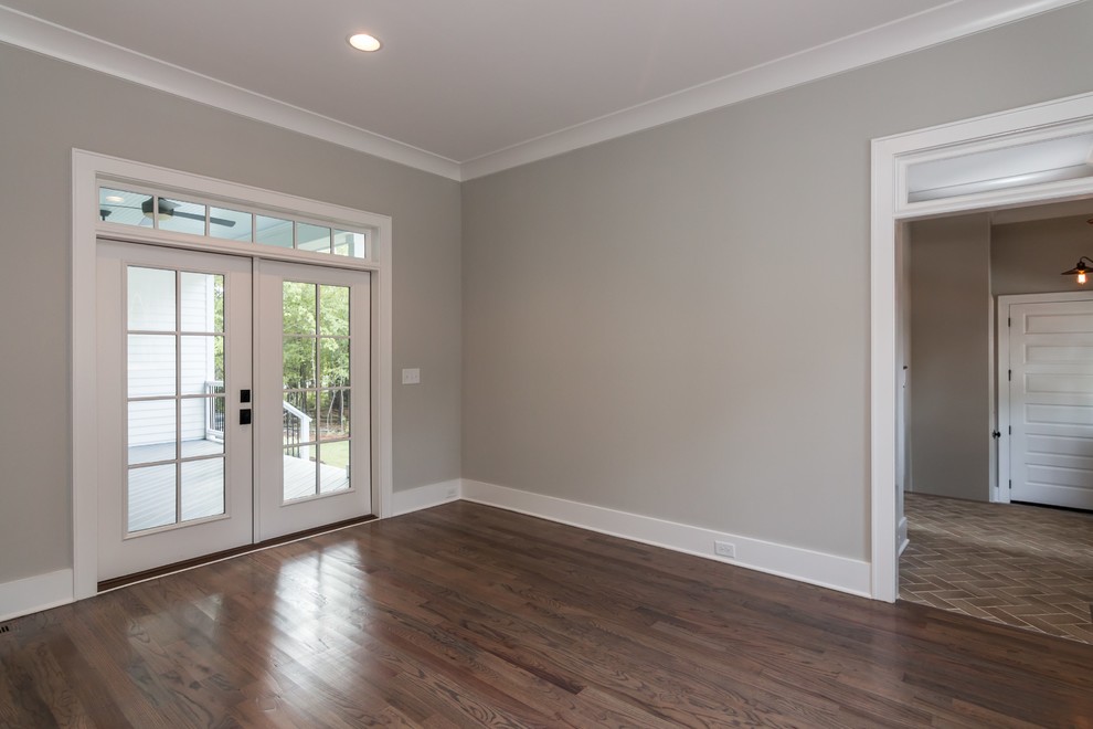 Example of a large country built-in desk medium tone wood floor study room design in Raleigh with gray walls