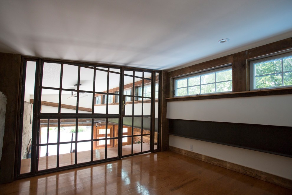 Diseño de despacho tradicional renovado de tamaño medio sin chimenea con paredes blancas, suelo de madera clara y suelo beige