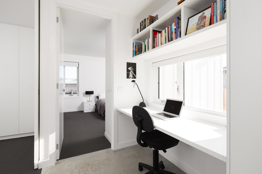 Esempio di un ufficio scandinavo con pareti bianche, pavimento in cemento e scrivania autoportante