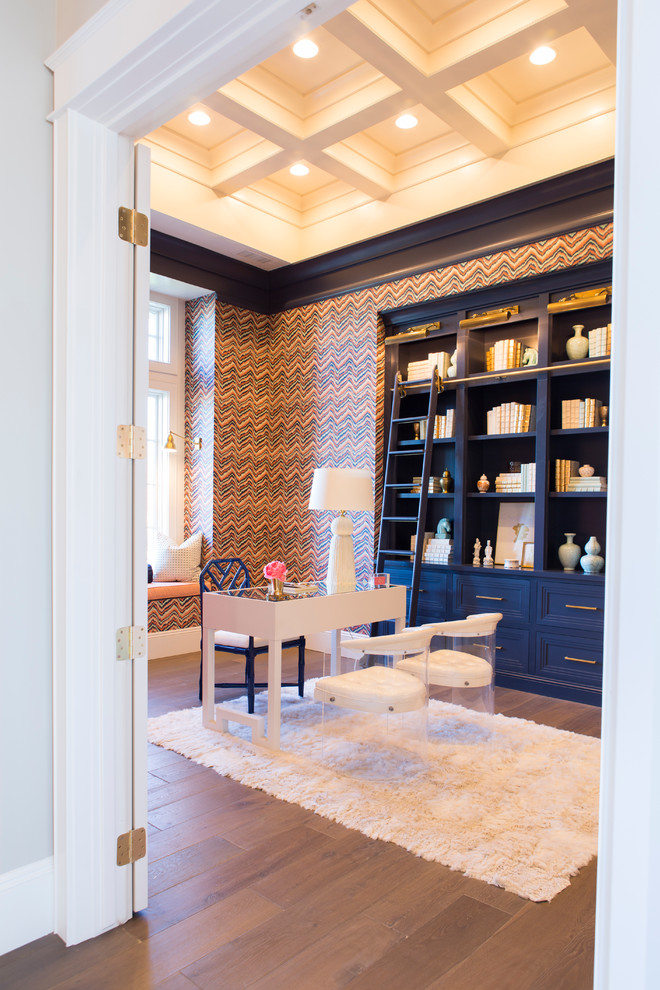 Inspiration för ett mellanstort vintage hemmabibliotek, med flerfärgade väggar, mellanmörkt trägolv, ett fristående skrivbord och brunt golv