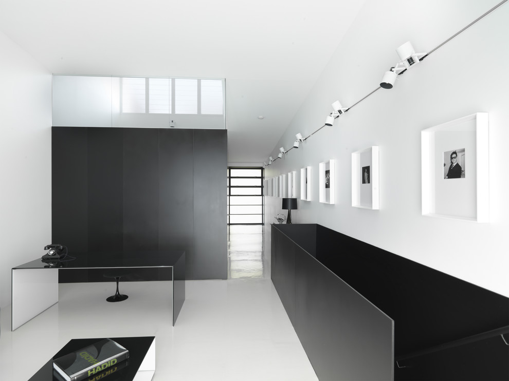 Diseño de despacho moderno con paredes blancas y escritorio independiente