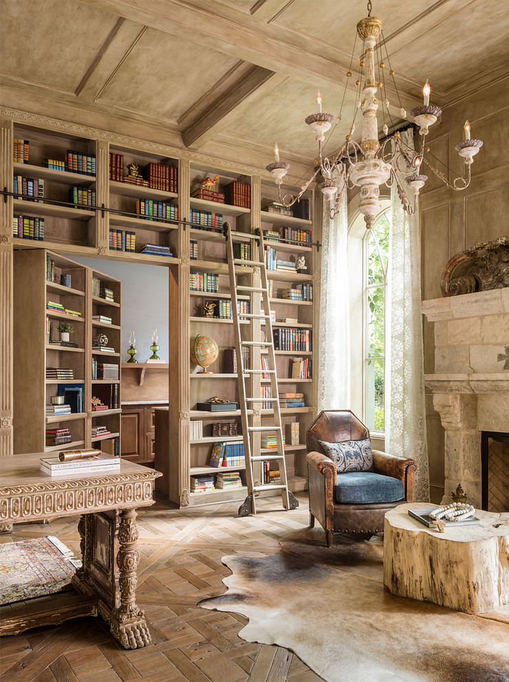 Inspiration for a mediterranean freestanding desk medium tone wood floor home office library remodel in New York with beige walls, a standard fireplace and a stone fireplace