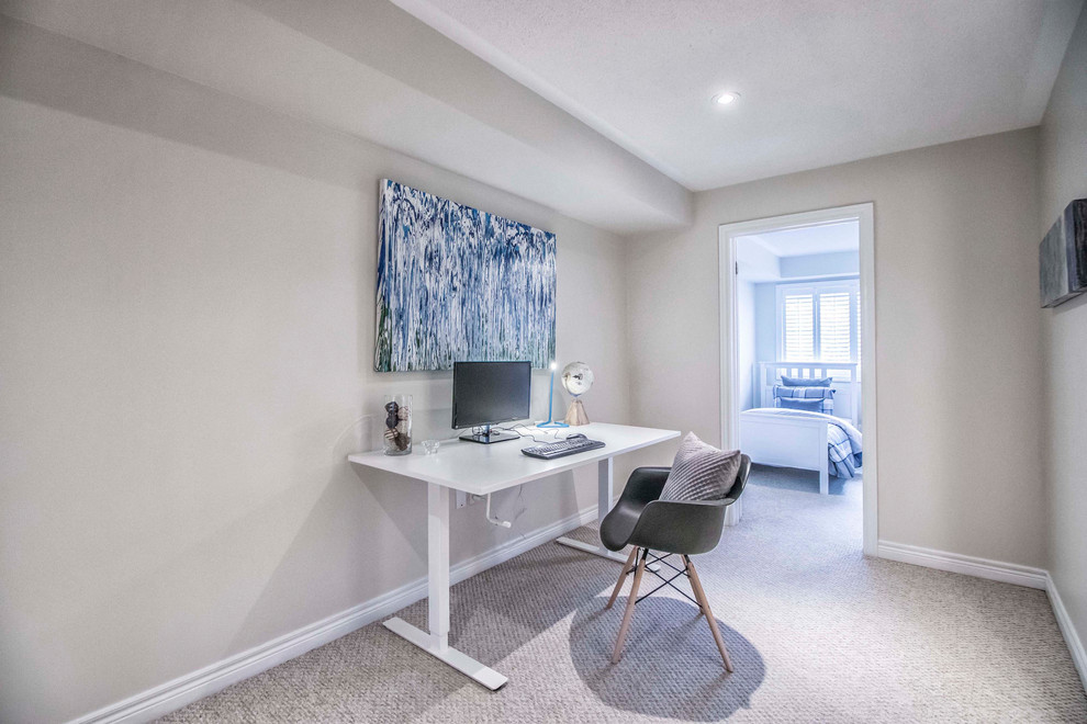 Kleines Modernes Arbeitszimmer mit Arbeitsplatz, beiger Wandfarbe, Teppichboden, freistehendem Schreibtisch und beigem Boden in Toronto